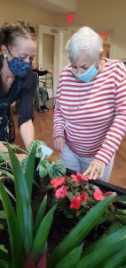 Memory care resident at The Landing of Lake Worth tends to garden