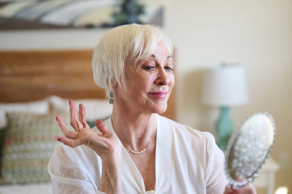 Woman looking in mirror in apartment