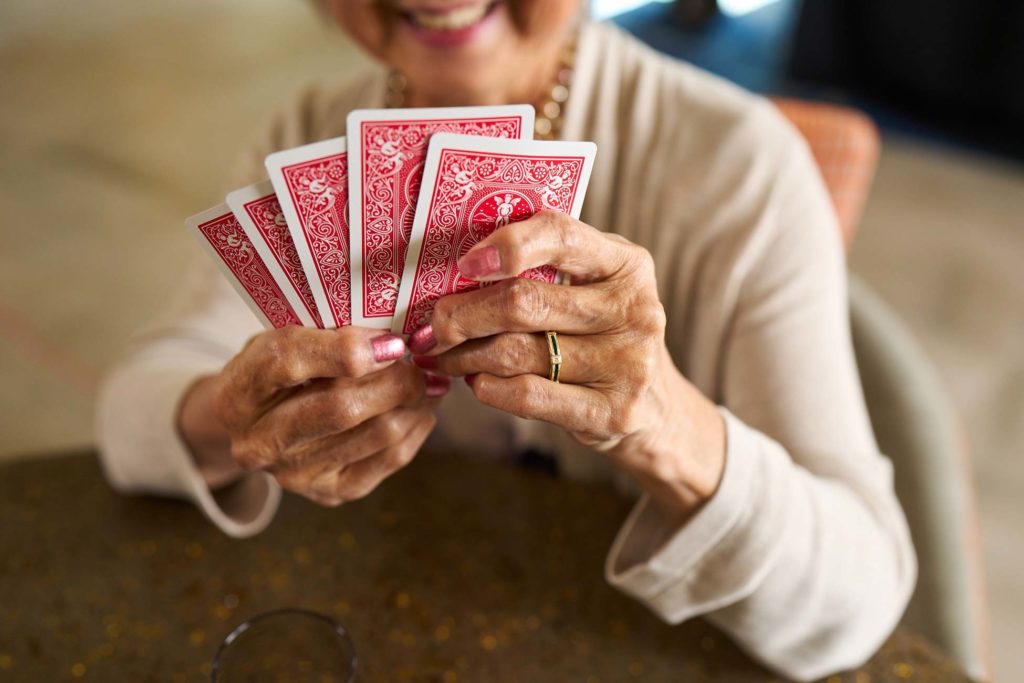 Senior holding playing cards