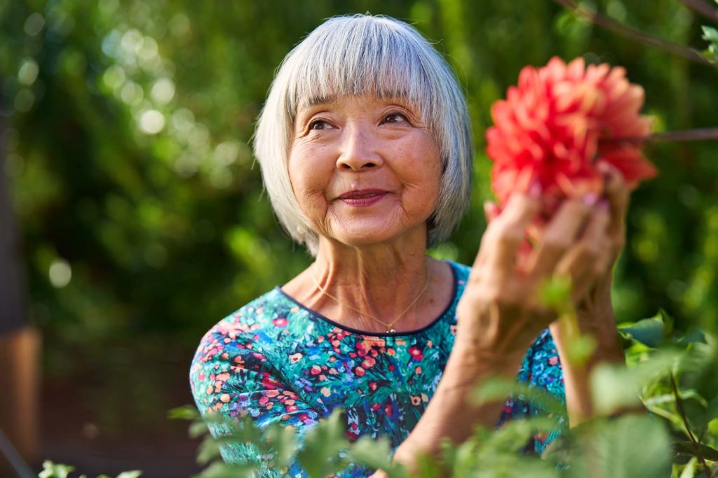 Senior woman with red flower