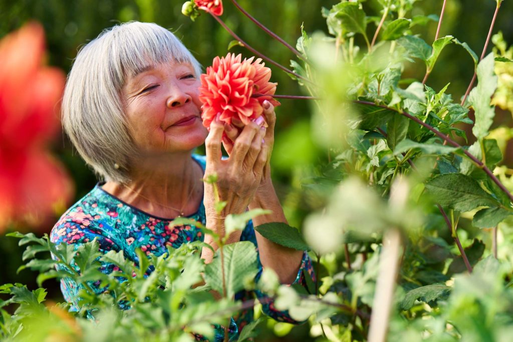 Senior woman smelling a flower