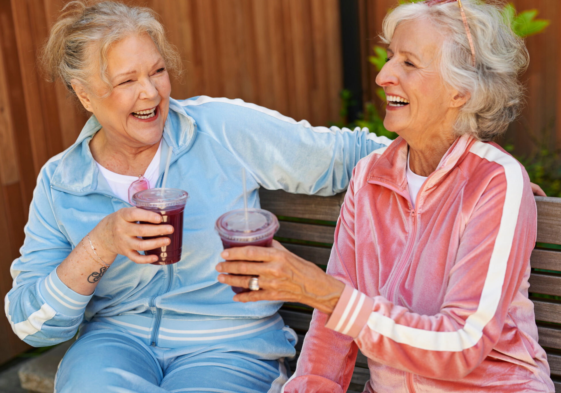 Older women in similar outfits drinking juice