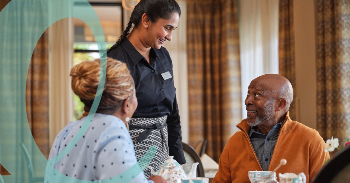 Woman serving man and woman in dining room