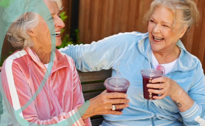 Women laughing wieht each other holding health drink
