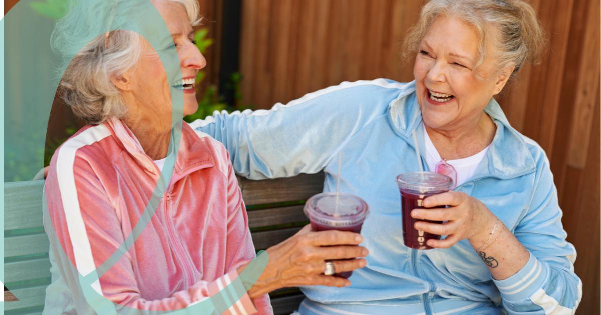 Women laughing wieht each other holding health drink